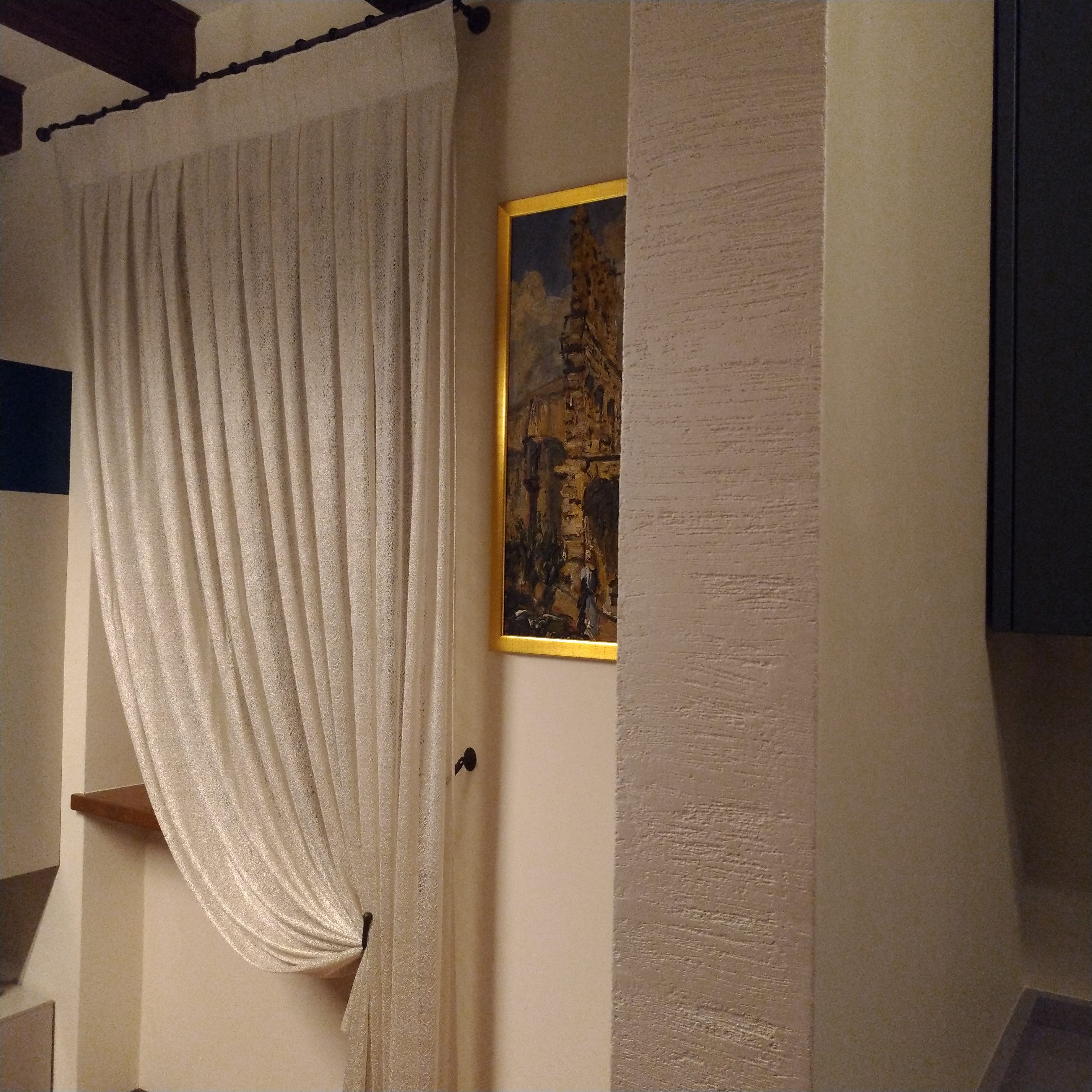 Il tessuto Agena a fili intrecciati per le tende raccolte con bracciali in  rame brunito in un interno classico e moderno. Mariano Tende Verona.