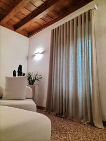 La tenda in puro lino color tabacco con profilo angolare laccato bianco per l'interno di una casa d'epoca del Primo Novecento. Le tende di Mariano, Verona.