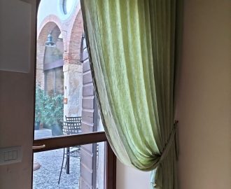 Le cortine verde olio in puro lino per una locanda frantoio della Valpolicella. Oil-green curtains in pure linen for a Valpolicella oil mill inn.